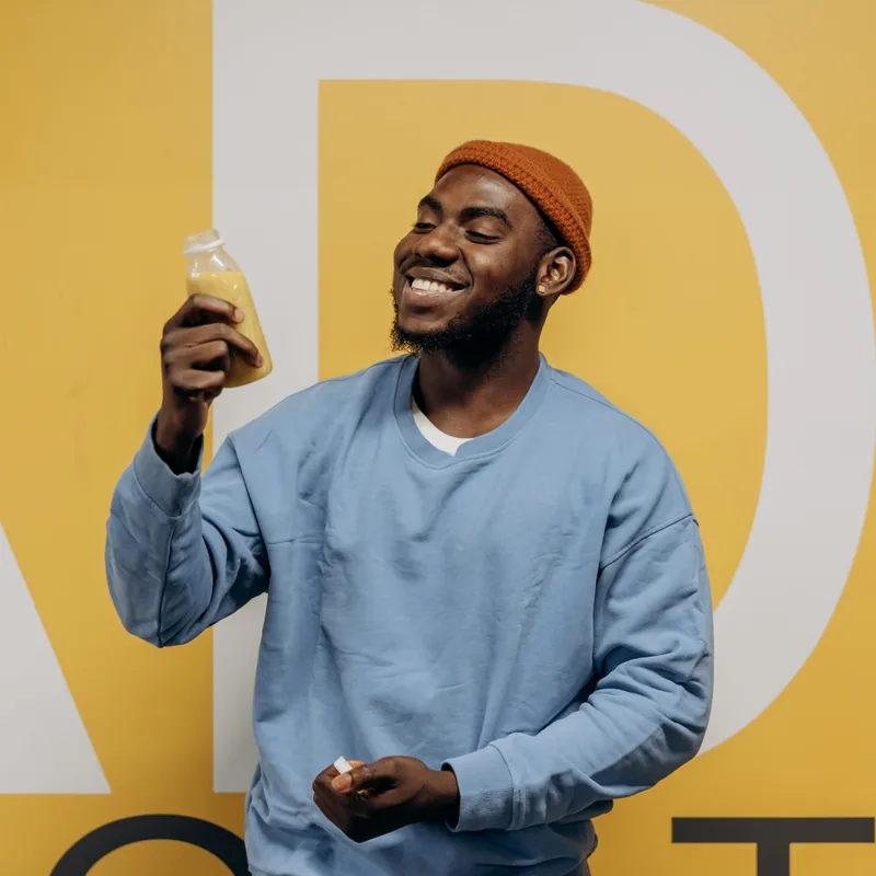 A man smiling with a bottled smoothie